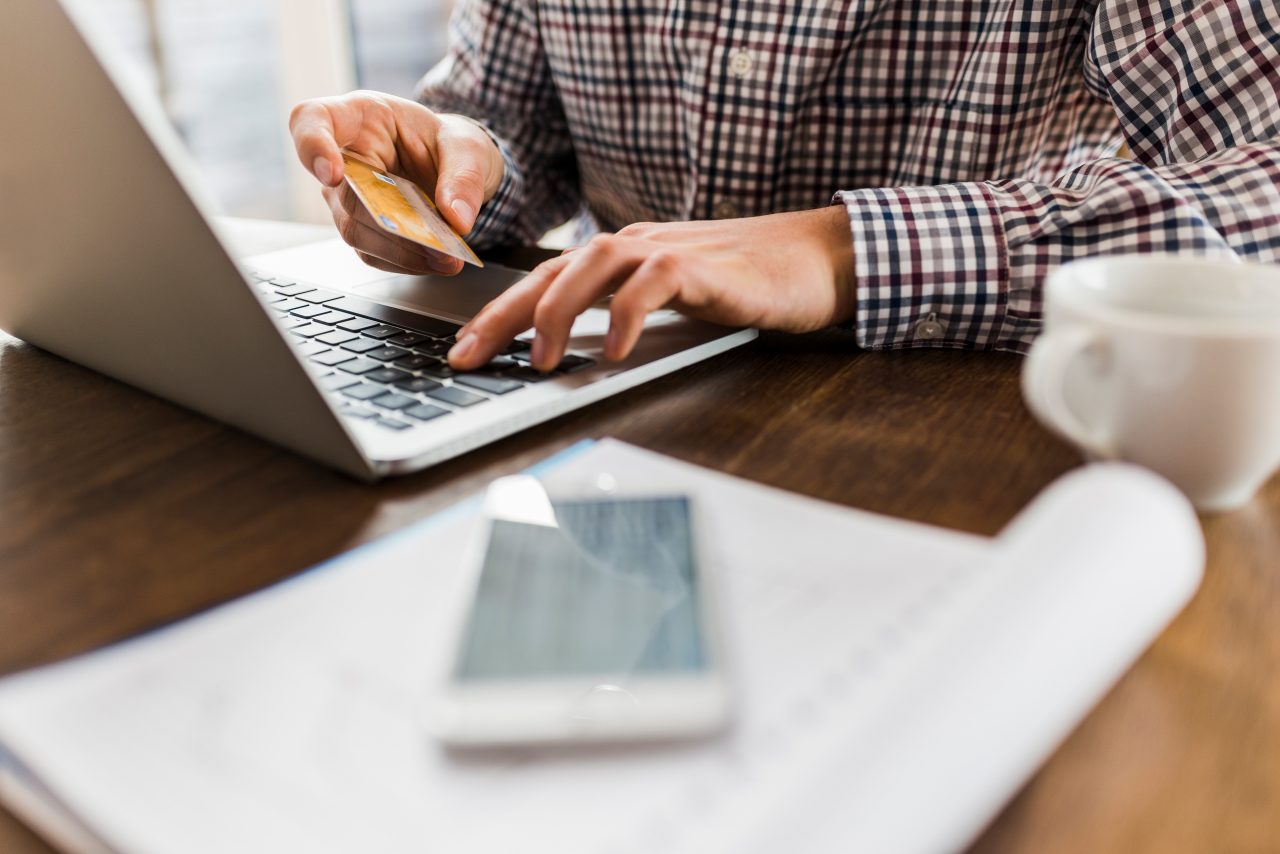 Person entering credit card number on laptop