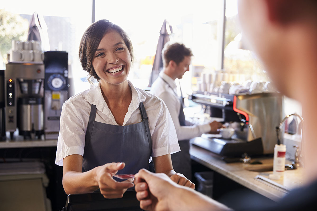 Cashier accepts payment from a customer in delicatessen